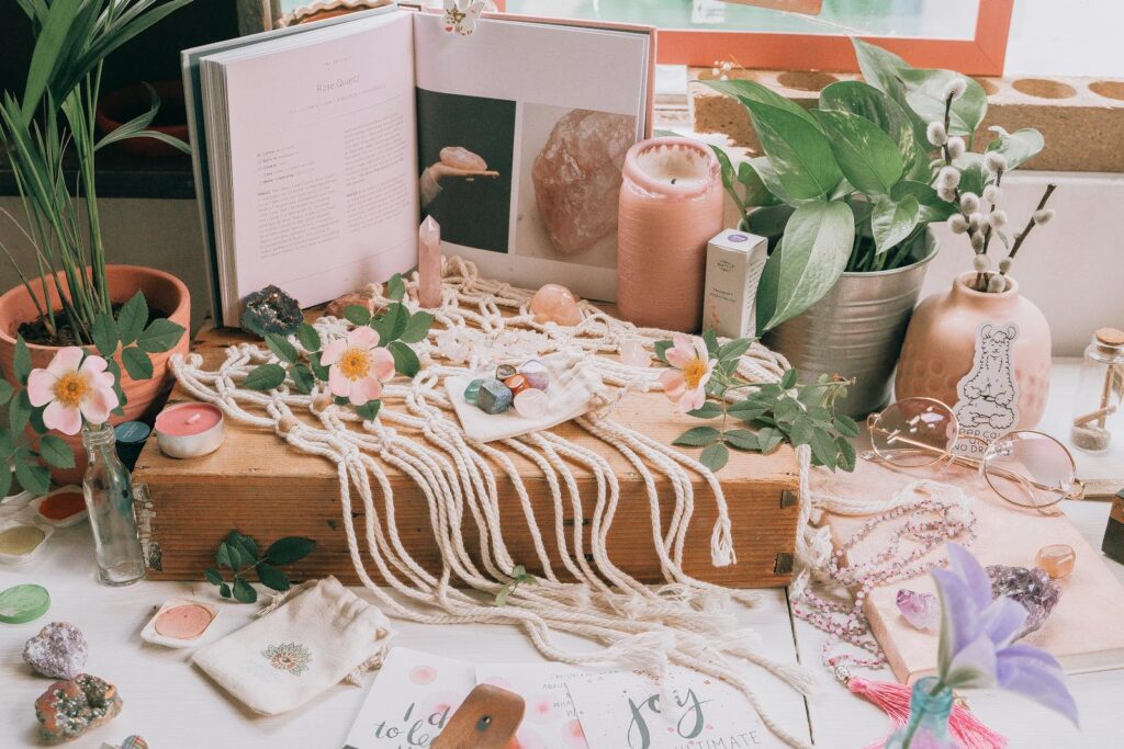 A boho-inspired still life featuring crystals, books, plants, and decor items.